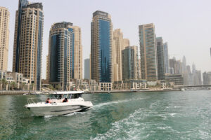 white boat on sea near high rise buildings