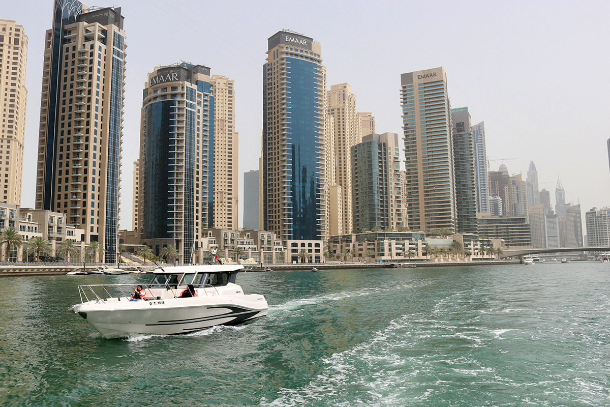 white boat on sea near high rise buildings